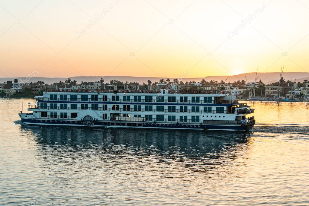 View of the Nile river with sailboats at golden colorful sunset in Luxor, Egypt
