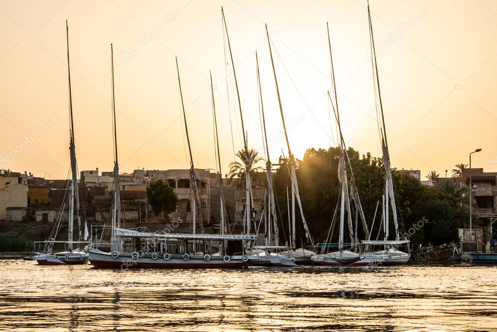 sunset Nile Aswan the West Bank with small village houses with fishing sailing boats felucca