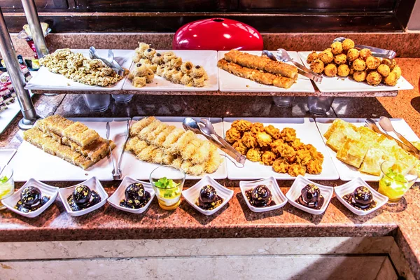 Grandes platos de dulces de Oriente Medio postre, baklava, pastelería, miel, nueces, fiesta de celebración en Egipto Makadi Bay —  Fotos de Stock
