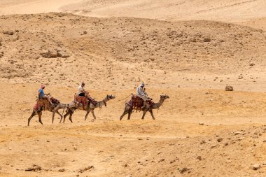 Kahire, Mısır 25.05.2018 - turistler ve Giza Yaylası kayalık çölde deve sürme kılavuzları
