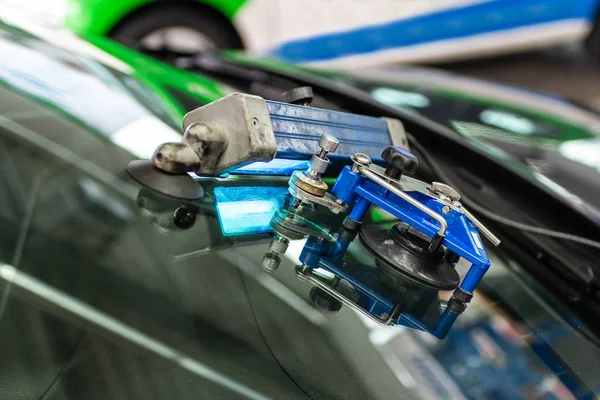 Man using repairing equipment to fix damaged cracked windshield — Stock Photo, Image