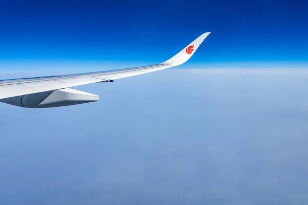 中国空、赤いウイングレット青い空雲に飛行機の翼を空気します。 — ストック写真