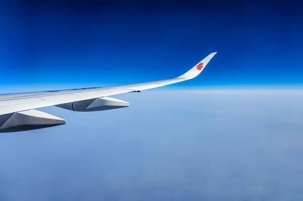 Air China wing av flygplan i himlen röd winglet blå himlen molnen — Stockfoto
