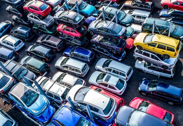 Lines of crushed cars wreck in scrapyard before being shredded recyling