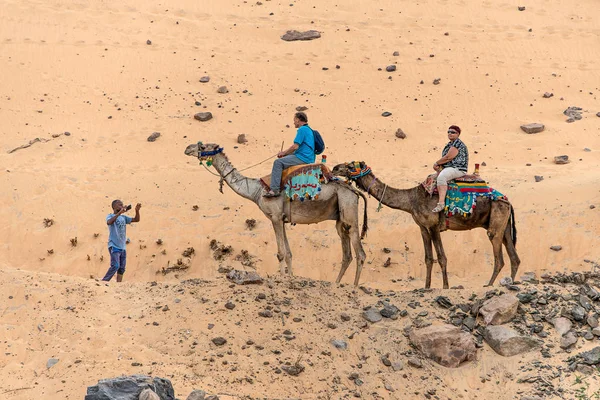 Aswan,Mısır 18.05.2018 Aswan bölgesindeki Nil Nehri'nin batı kıyısındaki Nubian köyüne deve turuna binen turistler — Stok fotoğraf