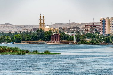 Aswan city Egypt panorama view from a boat on the west coast of the Nile on a sunny day clipart