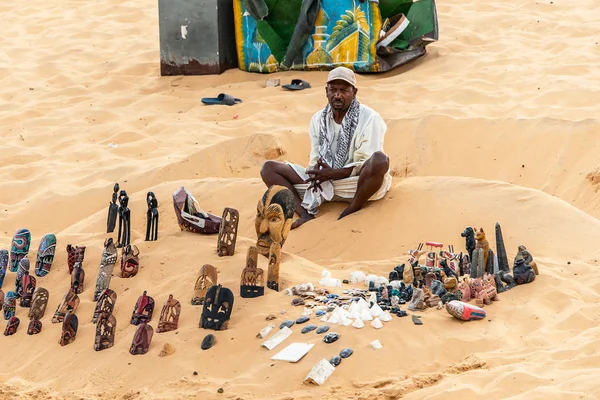 ASWAN EGYPT 20.05.18 Pria souvenier seller dengan rolling store di pantai pasir dekat Assuan di Mesir — Stok Foto