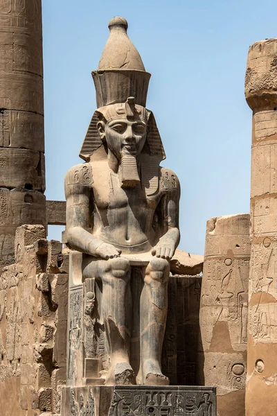 Egipto Templo de Luxor. granito Estatua de Ramsés II sentada frente a columnas — Foto de Stock