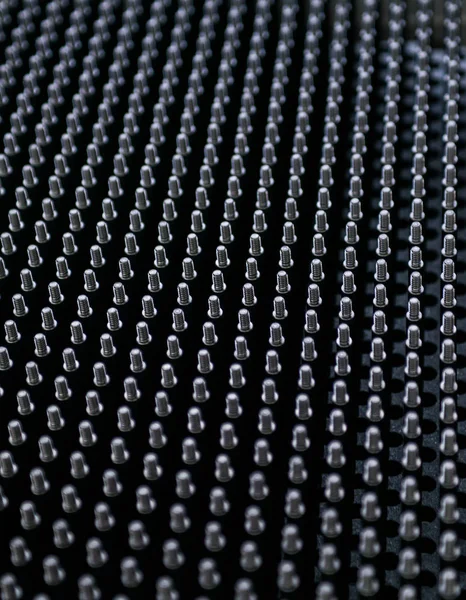 パターンの背景アートに並んだ黒いネジ糸ボルトのクローズアップショット — ストック写真