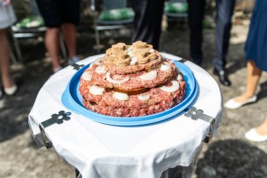 Düğün pastası çiğ domuz etli burgerler soğan, biberiye ve ekmek ile yakın plan bir düğünde servis edilir.
