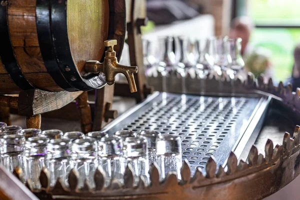 Régi tölgyfahordó whiskey-vel kis üvegekkel egy fa asztalon. homályos háttér party állomás beállítása előtt — Stock Fotó