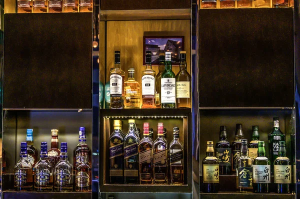 24.02.2019 Peking China - Wall with Bitters and alcohols whiskey bar counter bottles ambient tlight blurred background — Stock Photo, Image