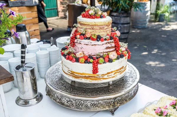 Hermoso delicioso pastel de boda en muchos niveles con frutas y bayas silvestres frescas — Foto de Stock