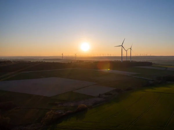 德国一个风力发电厂，在令人惊奇的落日下，风力涡轮机发电机的空中景象 — 图库照片