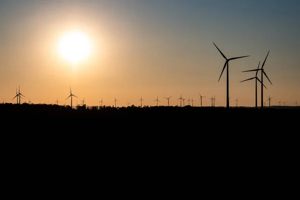 Silhueta preta de aerogeradores gerador de energia no pôr do sol incrível em um parque eólico na Alemanha — Fotografia de Stock