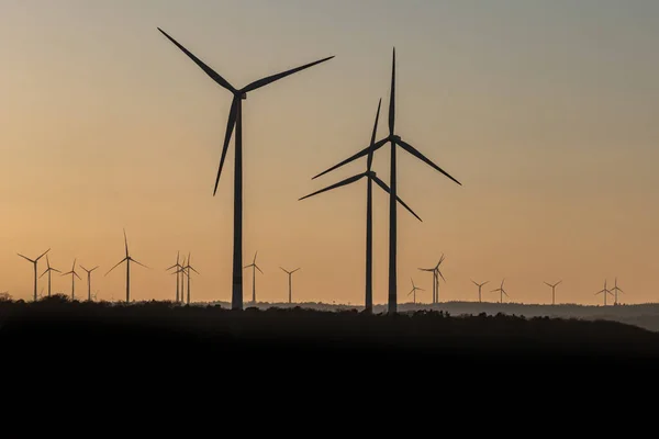 Negro silueta de aerogeneradores generador de energía en increíble puesta de sol en un parque eólico en Alemania — Foto de Stock