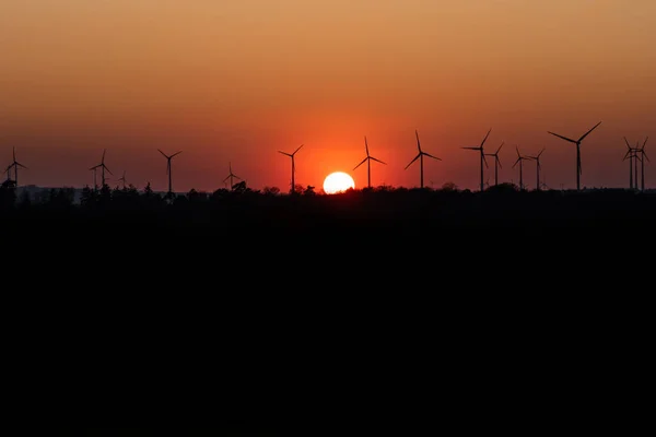 Negro silueta de aerogeneradores generador de energía en increíble puesta de sol en un parque eólico en Alemania — Foto de Stock