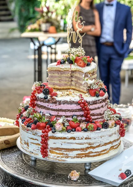 Hermoso delicioso pastel de boda en muchos niveles con frutas y bayas silvestres frescas — Foto de Stock