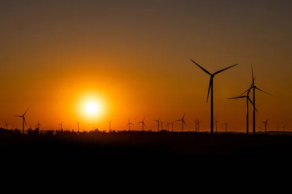 Negro silueta de aerogeneradores generador de energía en increíble puesta de sol en un parque eólico en Alemania — Foto de Stock