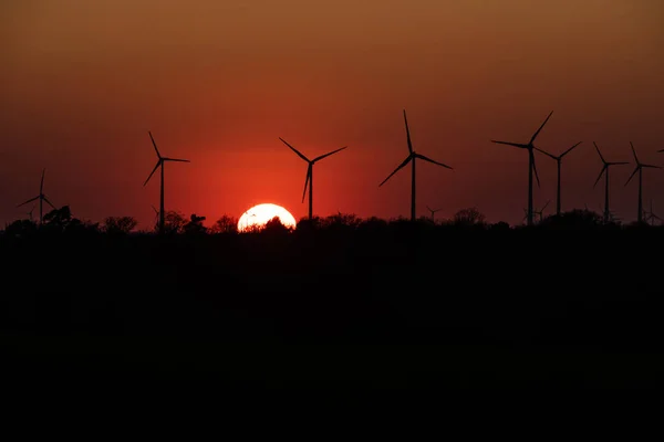 Silhueta preta de aerogeradores gerador de energia no pôr do sol incrível em um parque eólico na Alemanha — Fotografia de Stock