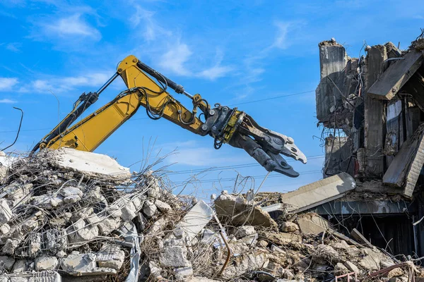 Máquina escavadora do local da demolição da casa de construção com máquina do triturador hidráulico e recipiente amarelo — Fotografia de Stock