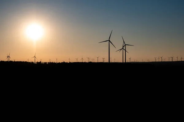 Negro silueta de aerogeneradores generador de energía en increíble puesta de sol en un parque eólico en Alemania — Foto de Stock