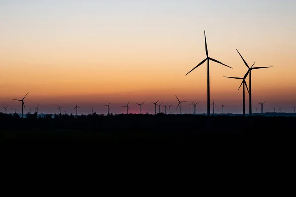 德国一个风力发电厂，在令人惊奇的落日下，风力发电机的黑色轮廓 — 图库照片