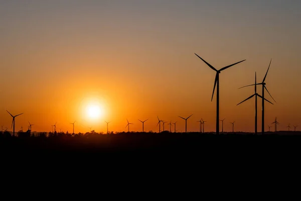 Silhueta preta de aerogeradores gerador de energia no pôr do sol incrível em um parque eólico na Alemanha — Fotografia de Stock