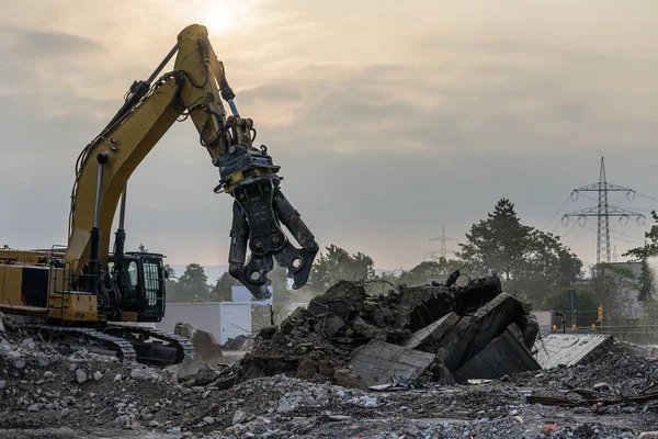 Stavební dům Demoliční místo Bagr s hydraulickým lisovacím strojem a žlutým kontejnerem — Stock fotografie