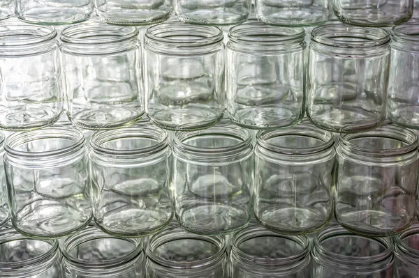 Beaucoup de verre pot vide verres rangée de miel de confiture avec couvercle capuchons fond abstrait bokeh — Photo