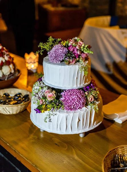 Beautiful delicious Wedding cake in many tiers with fresh wild flowers and roses — Stock Photo, Image