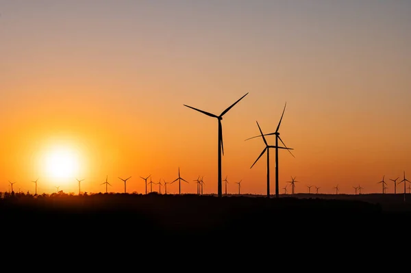 Silhueta preta de aerogeradores gerador de energia no pôr do sol incrível em um parque eólico na Alemanha — Fotografia de Stock