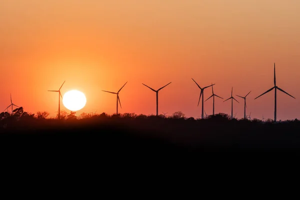 Schwarze Silhouette eines Windenergiegenerators im Sonnenuntergang in einem Windpark in Deutschland — Stockfoto