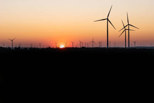 Black Silhouette of windturbines energy generator on amazing sunset at a wind farm in germany — Stock Photo, Image