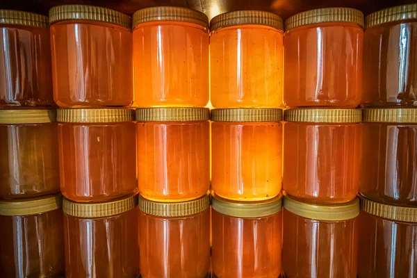 Tour et rangées de miel jaune doré dans un bocal en verre sur une planche de bois Fermer Espace de copie — Photo