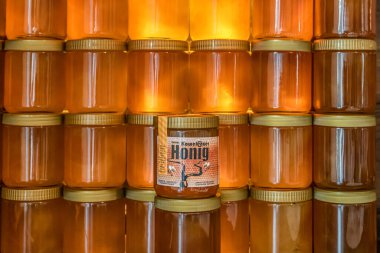 Koblenz Germany 14.06.2020 Tower and rows of Golden yellow honey in glass jar on wooden board Closeup Copy space