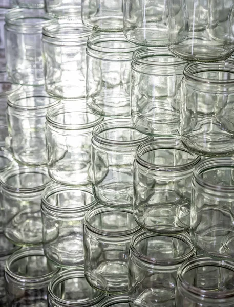 Beaucoup de verre pot vide verres rangée de miel de confiture avec couvercle capuchons fond abstrait bokeh — Photo