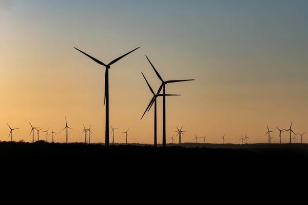 德国一个风力发电厂，在令人惊奇的落日下，风力发电机的黑色轮廓 — 图库照片