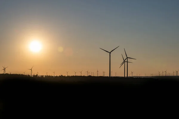 Zwart silhouet van windturbines energiegenerator op verbazingwekkende zonsondergang op een windpark in Duitsland — Stockfoto