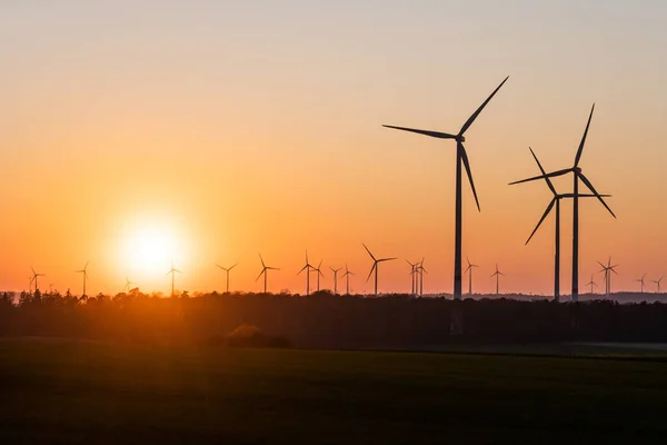 Silhueta preta de aerogeradores gerador de energia no pôr do sol incrível em um parque eólico na Alemanha — Fotografia de Stock