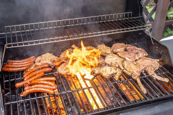Tomahawk revben nötkött stek ans sausages on hot black grill with flames bbq — Stockfoto