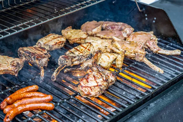 Tomahawk revben nötkött stek ans sausages on hot black grill with flames bbq — Stockfoto