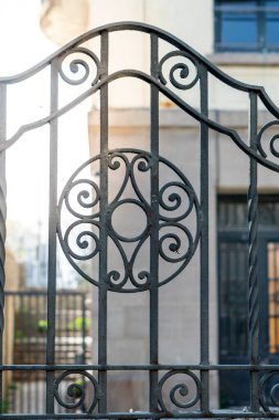 Güneş büyük bir malikanenin arkasında batar demir çitler döşeyerek etkileyici mimarisi ve metal korkulukları üzerine uzun gölgeler bırakır..