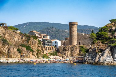 Girona, İspanya-12 Ağustos 2025. Tossa de mar, İspanya, ortaçağ eski kasabası ve kumsal güneşli bir yaz gününde insanlarla dolup taşıyor.