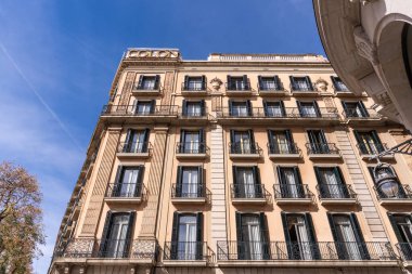 Görkemli bir Barselona kulesi, karmaşık Art Nouveau mimarisi ve pencereleriyle süslenmiş. Yerleşim yerlerinde bulutlu bir gökyüzünün arkaplanına karşı görkemli bir şekilde duruyor..