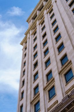 Gökyüzüne karşı dik duran ikonik kulelerin ve pencerelerle kaplı cephelerin yer aldığı geniş şehir siluetinin alçak açılı görüntüsü.