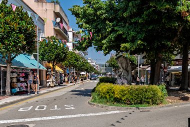 Girona, İspanya-12 Ağustos 2025. Eski Tossa de Mar, Costa Brava, İspanya 'daki dar ve işlek bir alışveriş caddesinde yürüyen turistler, Akdeniz kıyısındaki bir kasabada yaz tatili turizmi