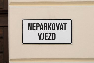 Çek dilinde Neparkovat Vjezd (park girişi yok) tabelası. Evin duvarında beyaz tabela var. Araba sürücülerine arabalarını buraya park etmemelerini söyle..