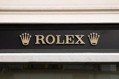 PRAG, CZECHIA - 29. Mayıs 2025: Mağaza cephesinde Rolex logosu tabelası. Duvarında taç olan amblemin yakın çekimi. Avrupa 'da İsviçre markasının lüks saat butiği..
