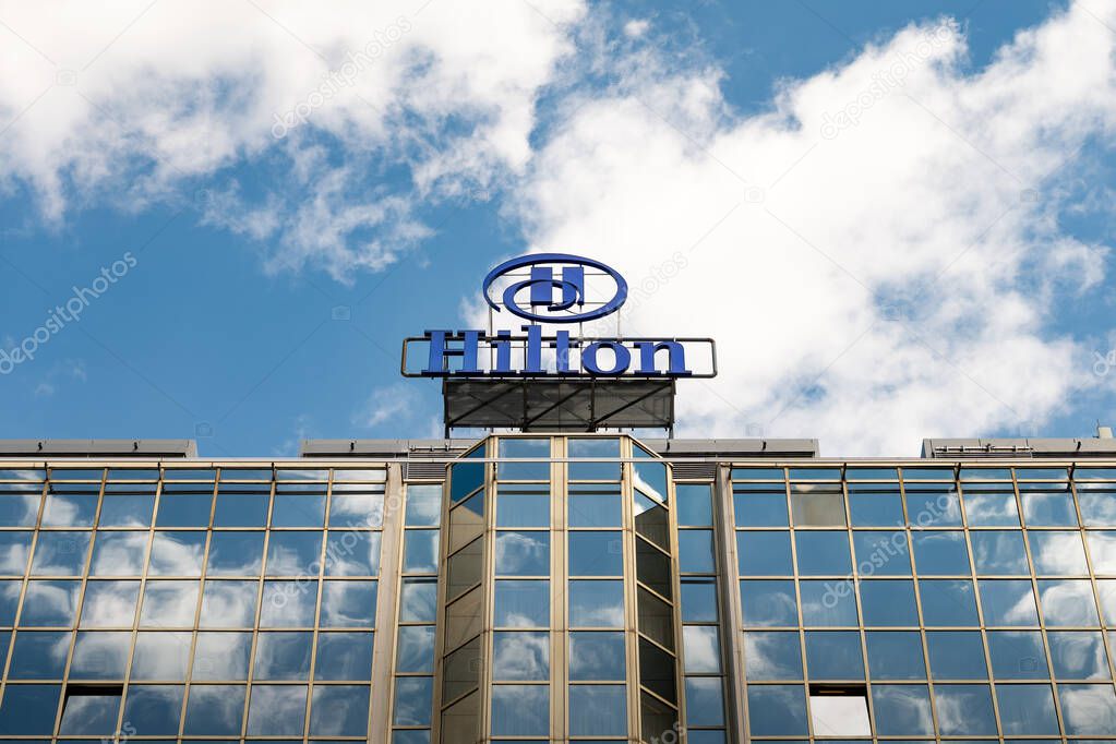 PRAGUE, CZECHIA - 30. May 2025: Hilton logo sign of the American hotel brand on a building. Business in the hospitality and travel industry. Exterior of the tall house against the sky.
